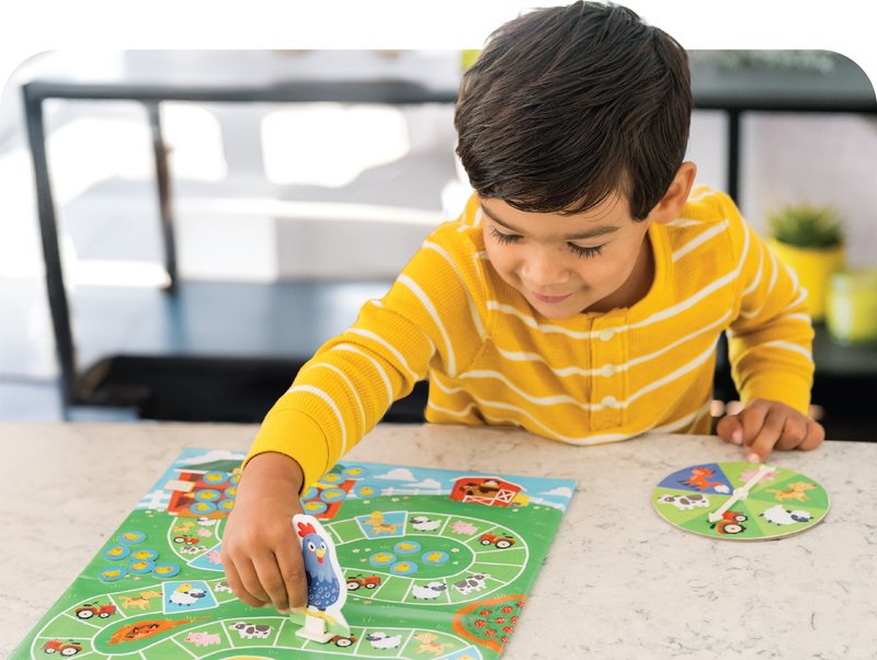 Preschooler moving a piece along a game path